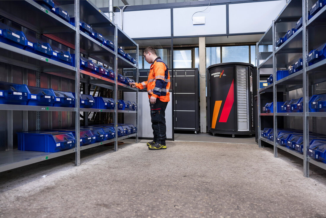 Arbeiter ordnet etwas in blaue Kisten