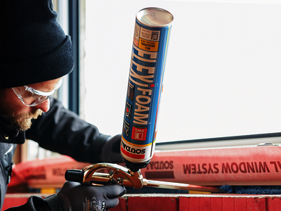 Ö-Normschu Arbeiter klebt etwas an einem Fenster