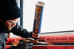 Arbeiter klebt etwas an einem Fenster