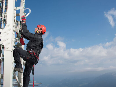Mann klettert einen Mast hinauf