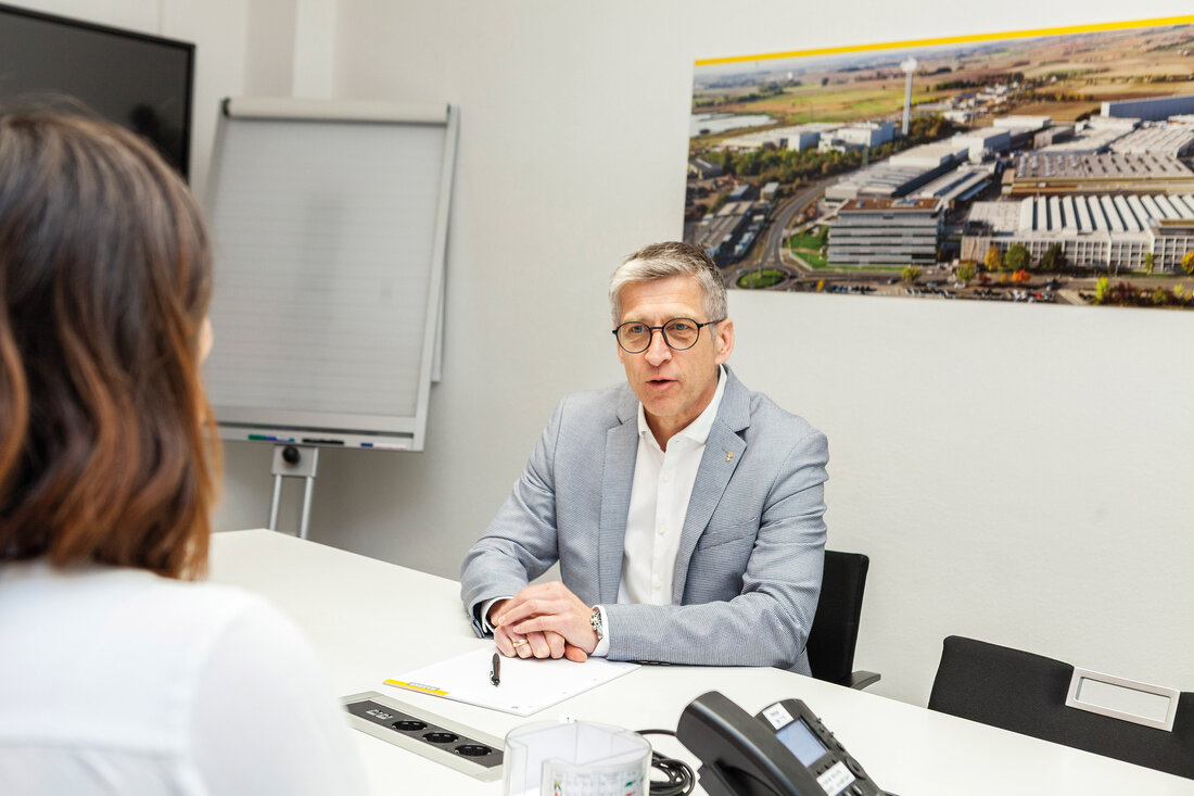 Gerald Wolfsegger sitzt auf einem Schreibtisch im Gespräch