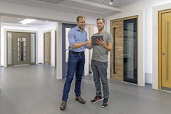 Zwei Personen in einem Beratungsgespräch und im Hintergrund Türen 