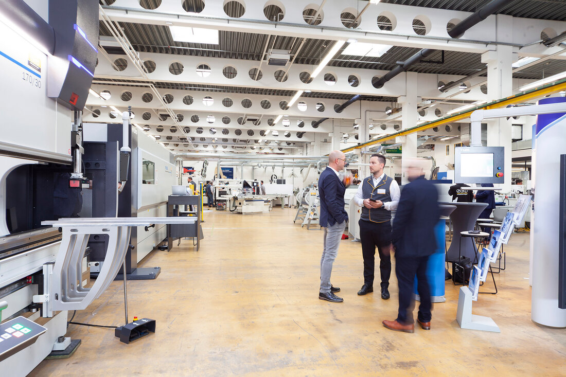 Personen in der Maschinenhalle bei den Metallbearbeitungsmaschinen