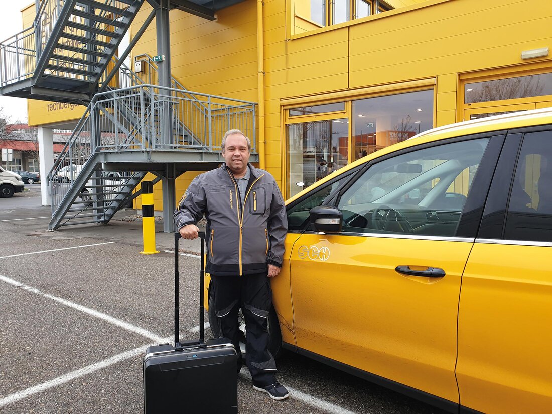 Mann vor gelbem Auto