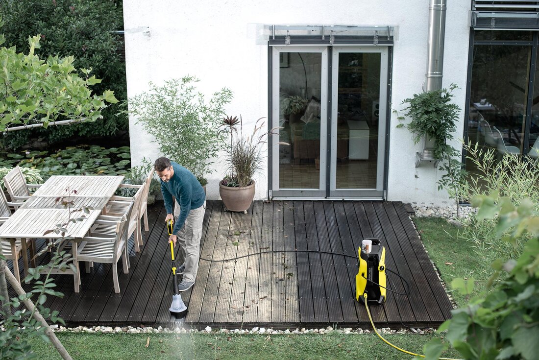 Mann reinigt Terrasse mit Kärcher