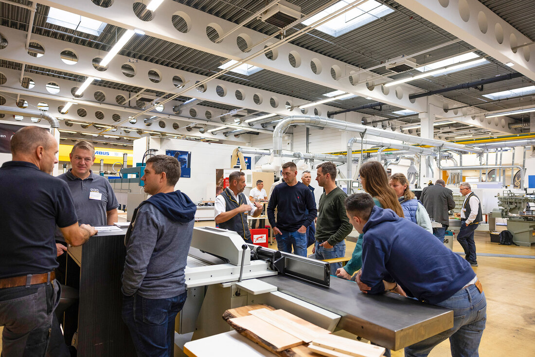 Personen in der Maschinenhalle, die miteinander sprechen. 