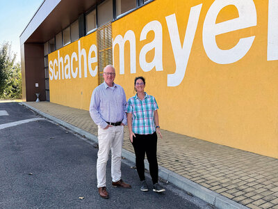 Mann und Frau stehen vor einer gelben Mauer
