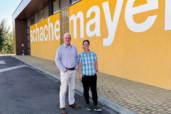 Mann und Frau stehen vor einer gelben Mauer