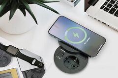 Schreibtisch mit Handy und Uhr, die gerade aufgeladen werden