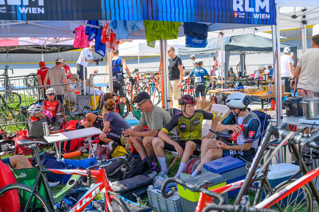 Viele Radfahrer sitzen im Velodrom im Schatten