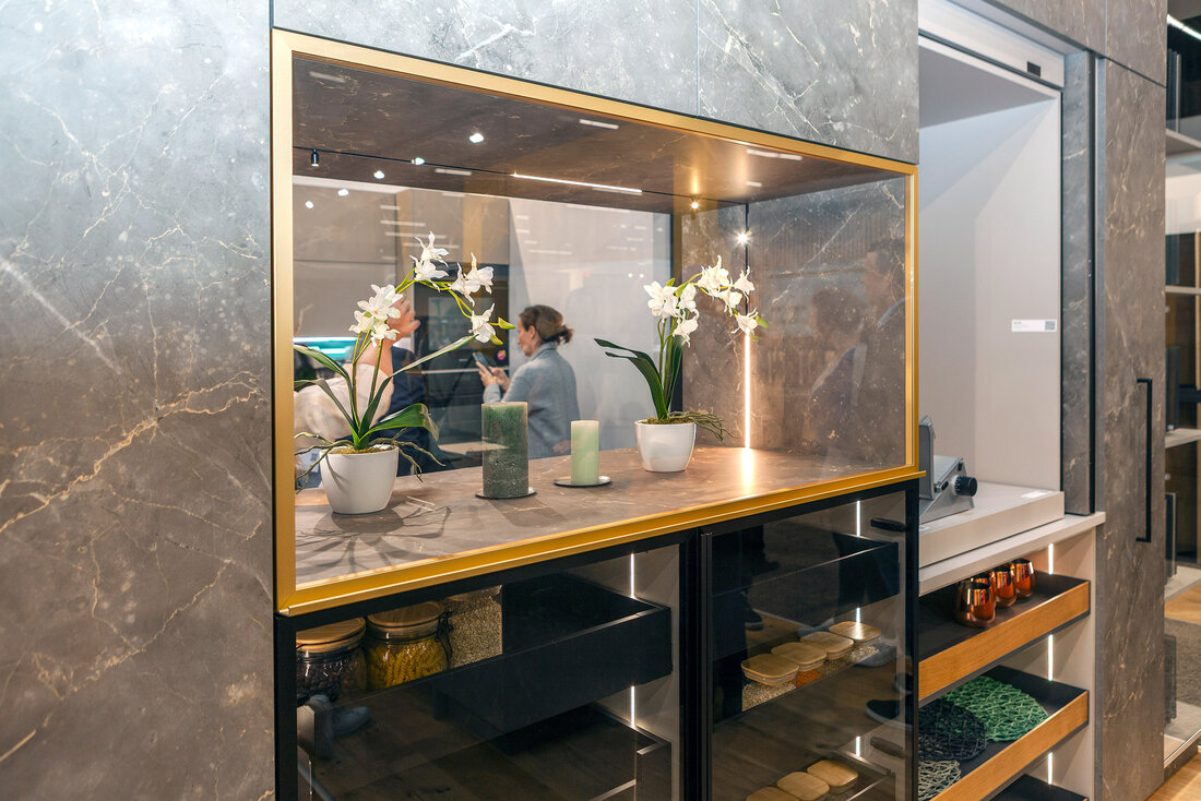 Weinkühlschränke und eine goldene Vitrine mit Blumen darin