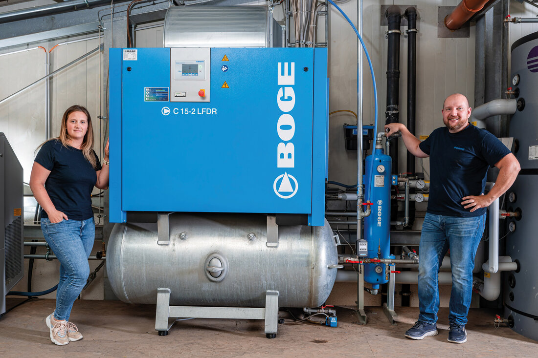 Schraubenkompressor mit Frau und Mann daneben