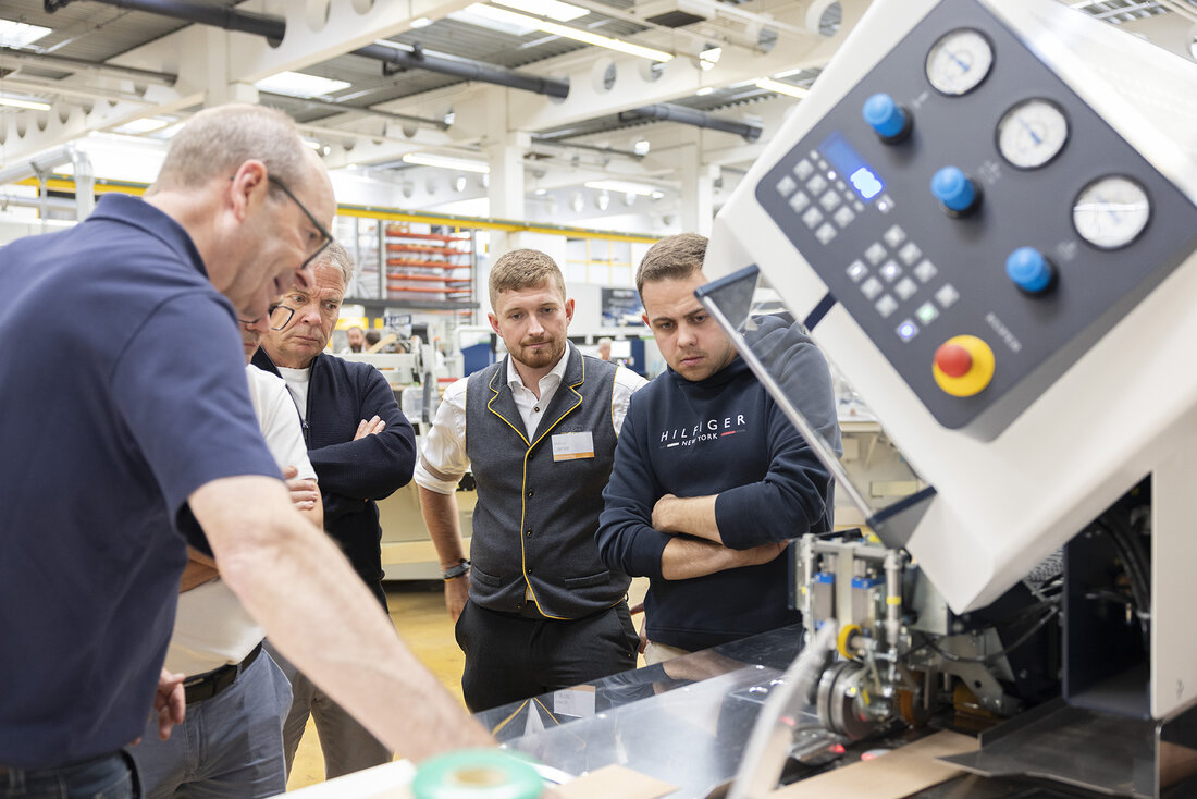 Menschen stehen rund um eine große Maschine