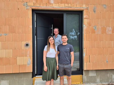 Inotherm Rohbau Drei Menschen stehen vor einer Inotherm Haustüre eines Rohbaus