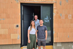 Drei Menschen stehen vor einer Inotherm Haustüre eines Rohbaus