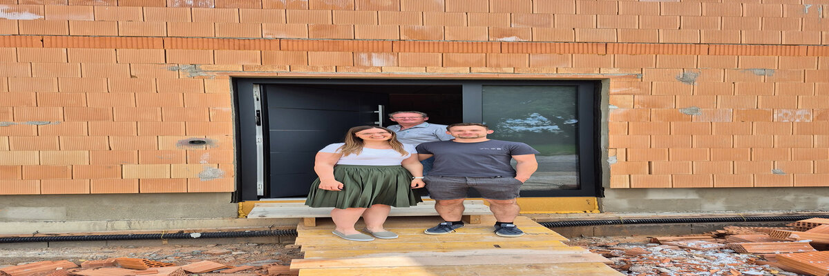 Drei Menschen stehen vor einer Inotherm Haustüre eines Rohbaus