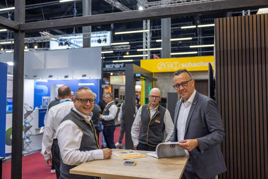 Menschen im Gespräch an einem Messestand