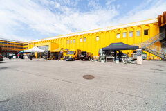 Gelbes Gebäude mit Ständen davor