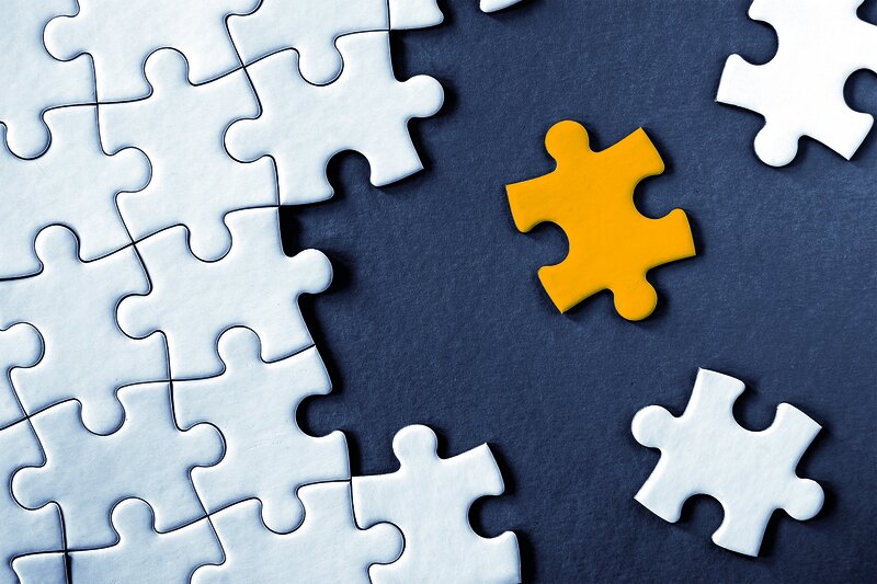 Close-up view of white jigsaw puzzle pieces on grey background