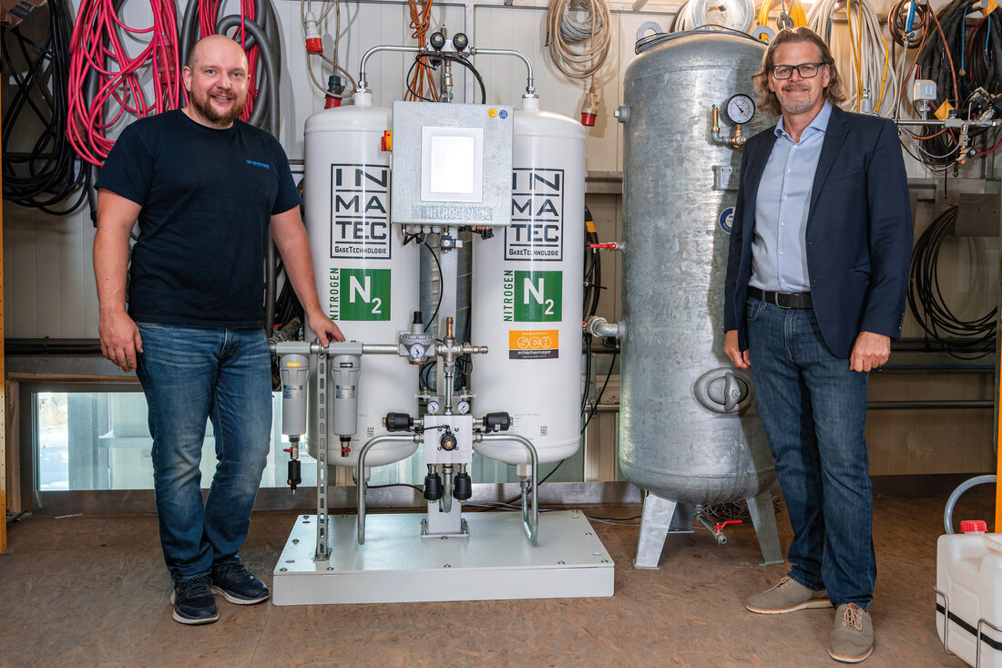 Schraubenkompressor mit zwei Männern daneben